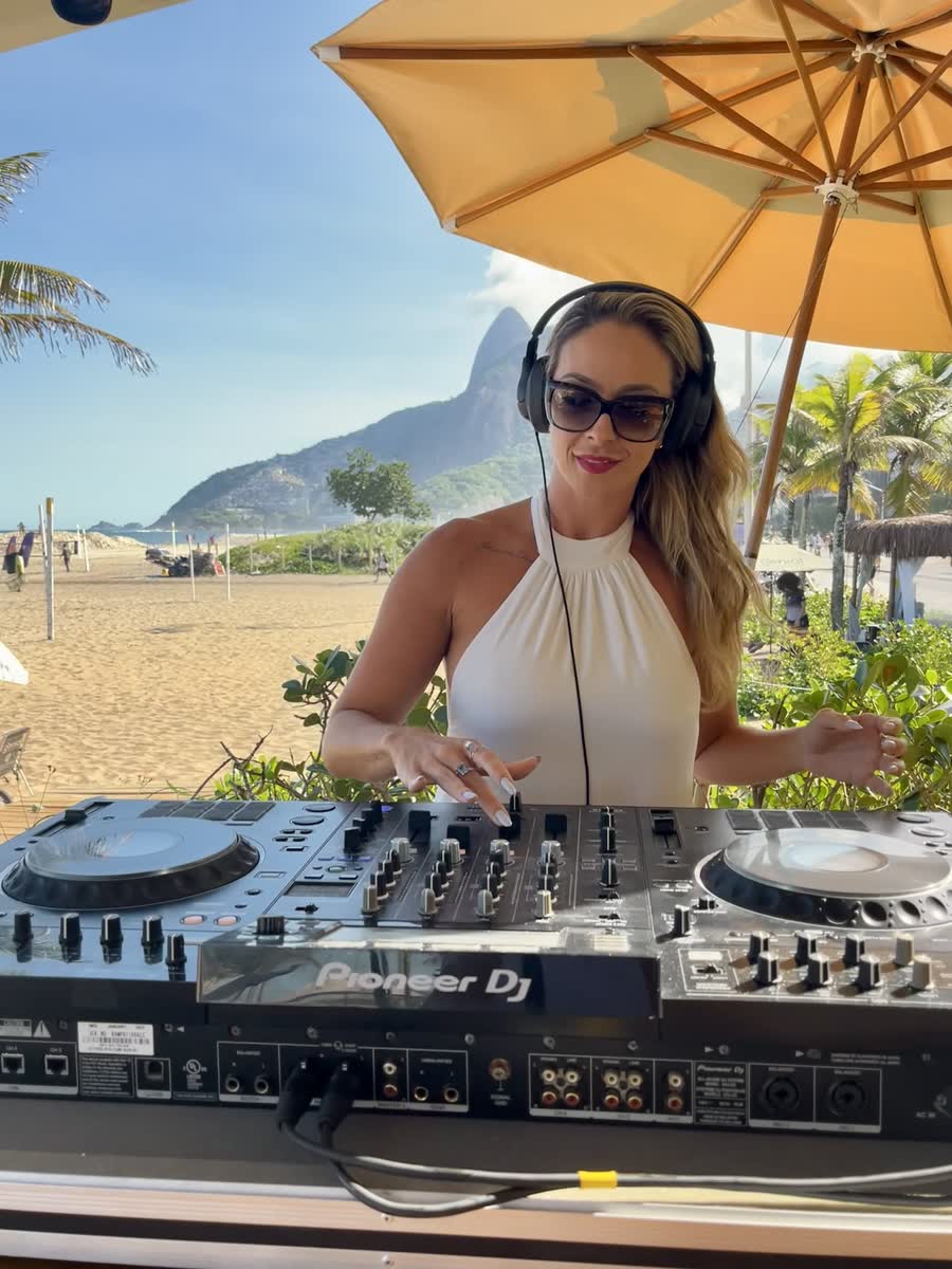Muryel tocando no fim de tarde no Clássico Beach Club, com o Dois Irmãos ao fundo